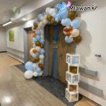 Newborn hospital room setup with balloon arch and baby name boxes