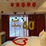 Romantic hotel room with red and white balloons and floral arrangement