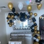 Party balloons with black, gold, and white color scheme