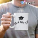 Custom graduation coffee mug with text "في بيتنا خريج" and space for personalization
