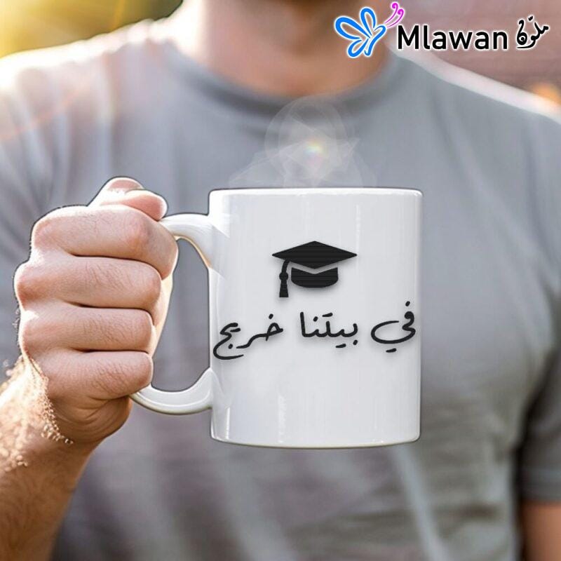 Custom graduation coffee mug with text "في بيتنا خريج" and space for personalization