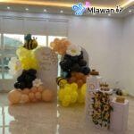 yellow and black party balloons and honeycomb centerpieces
