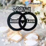 Black wooden plaque with Arabic "كتبنا الكتاب" and couple names