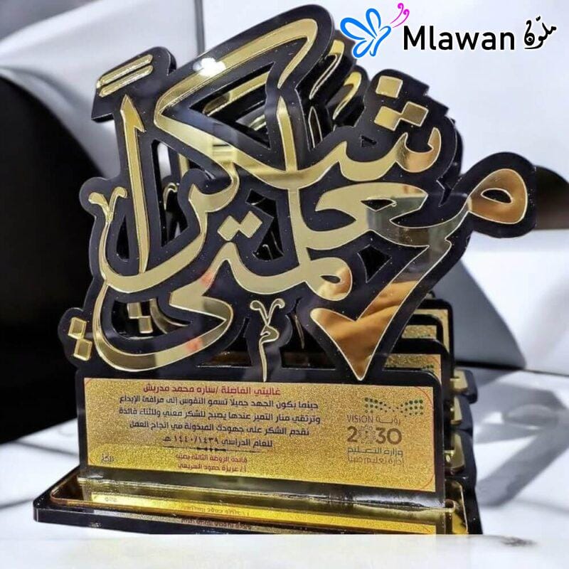 Personalized teacher plaque engraved with "شكرا معلمتي" on wooden desk