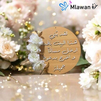 لافتة باب دائرية مع عبارة "لقد بني هذا البيت بالحب" مكتوبة بخط عربي أنيق وزخارف زهرية خلفية
