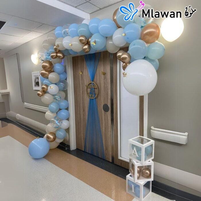 festive arc balloon setup in hospital room for baby boy