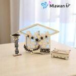 Graduation guest book with pen holder and wooden graduation cap name tags displayed on a table