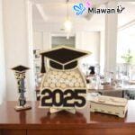 Graduation guest book with pen holder and wooden name tags displayed on a table